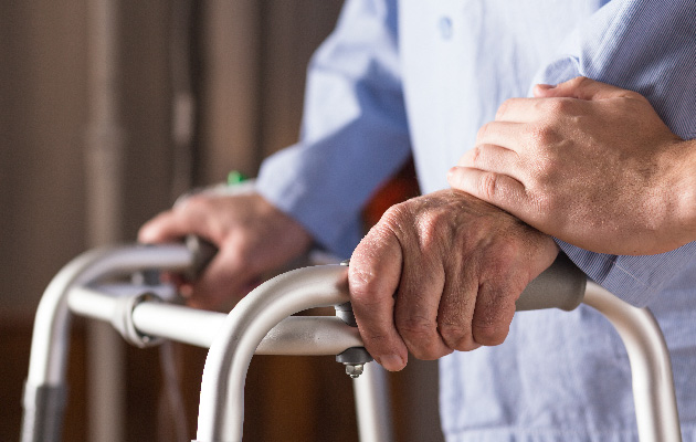 Image of senior disabled person holding walking